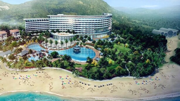 Un resort con un gran edificio, piscina y playa.