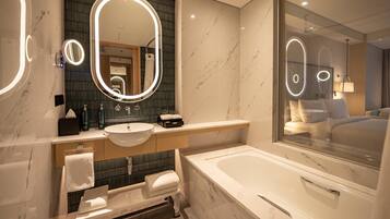 A modern bathroom with a large mirror, a sink, a bathtub, and a shower.