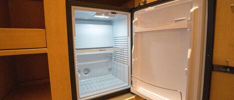 An open refrigerator with a wooden interior and a metal handle.