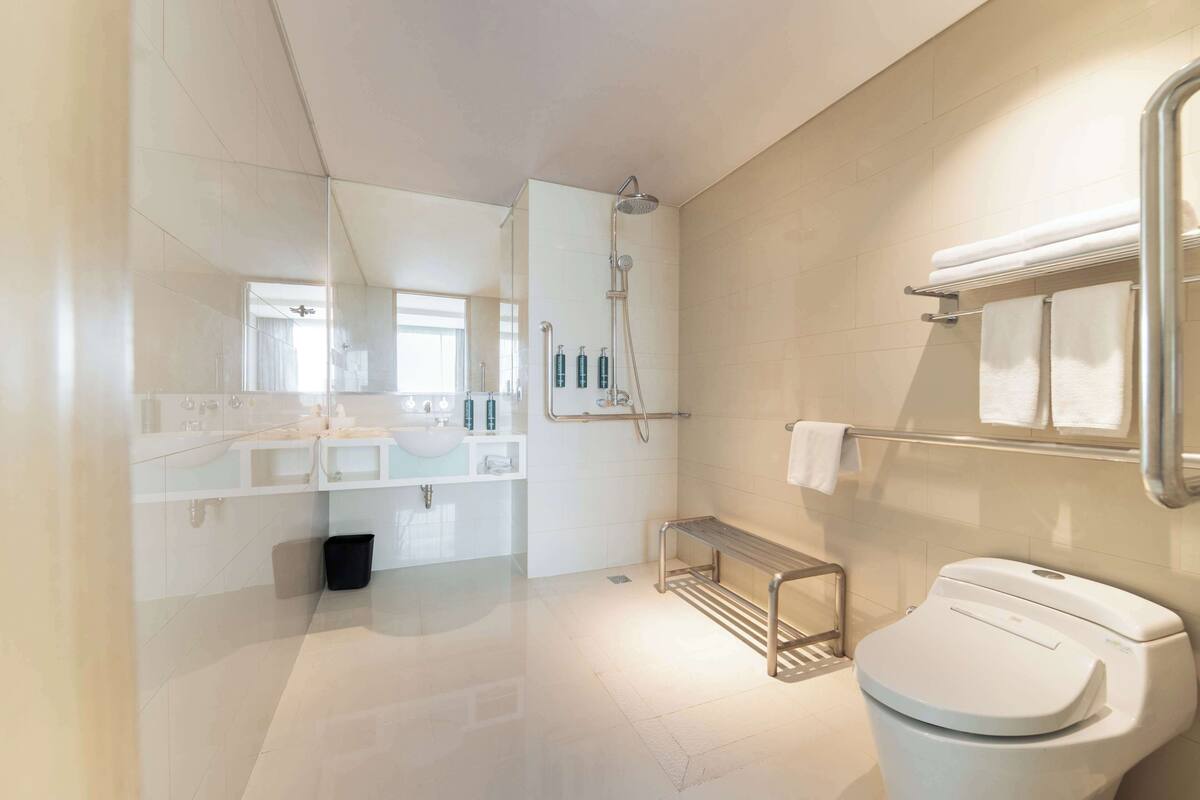 A modern bathroom with a toilet, shower, and sink area.