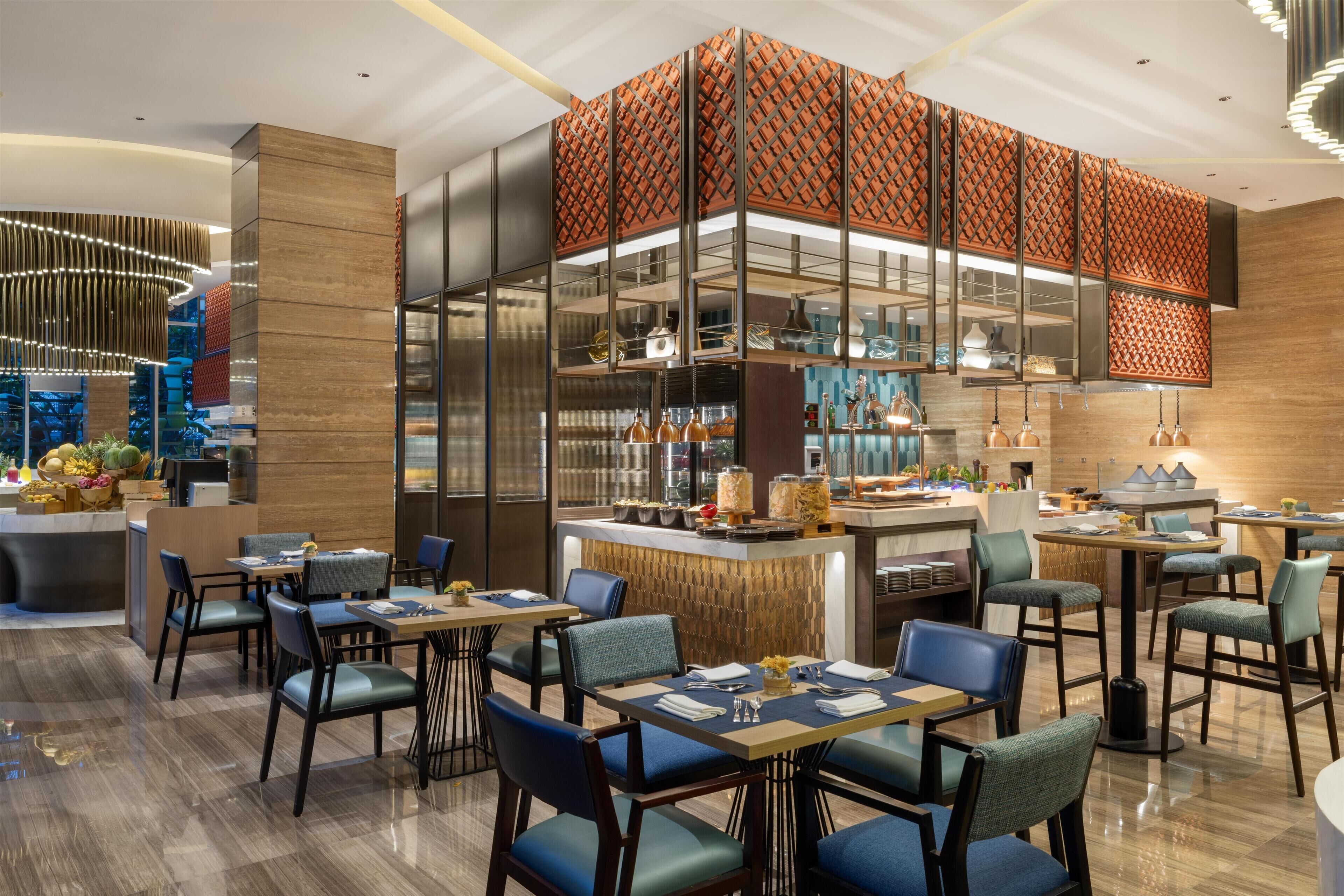 A modern restaurant with a central bar, seating arrangements, and a decorative wall.