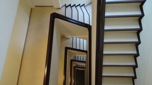 Una escalera con barandilla y un espejo que refleja los escalones.