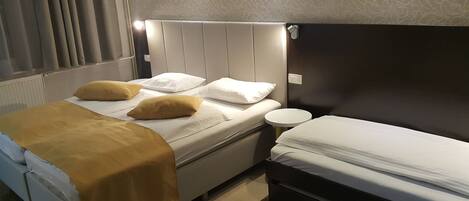 Una habitación de hotel con una cama, una mesita de noche y una pequeña mesa redonda.