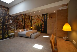 Un dormitorio moderno con cama, mesita de noche y escritorio con lámpara.