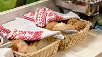 Zwei Korbflechte Körbe, gefüllt mit verschiedenen Brotsorten auf einer Küchenarbeitsplatte.