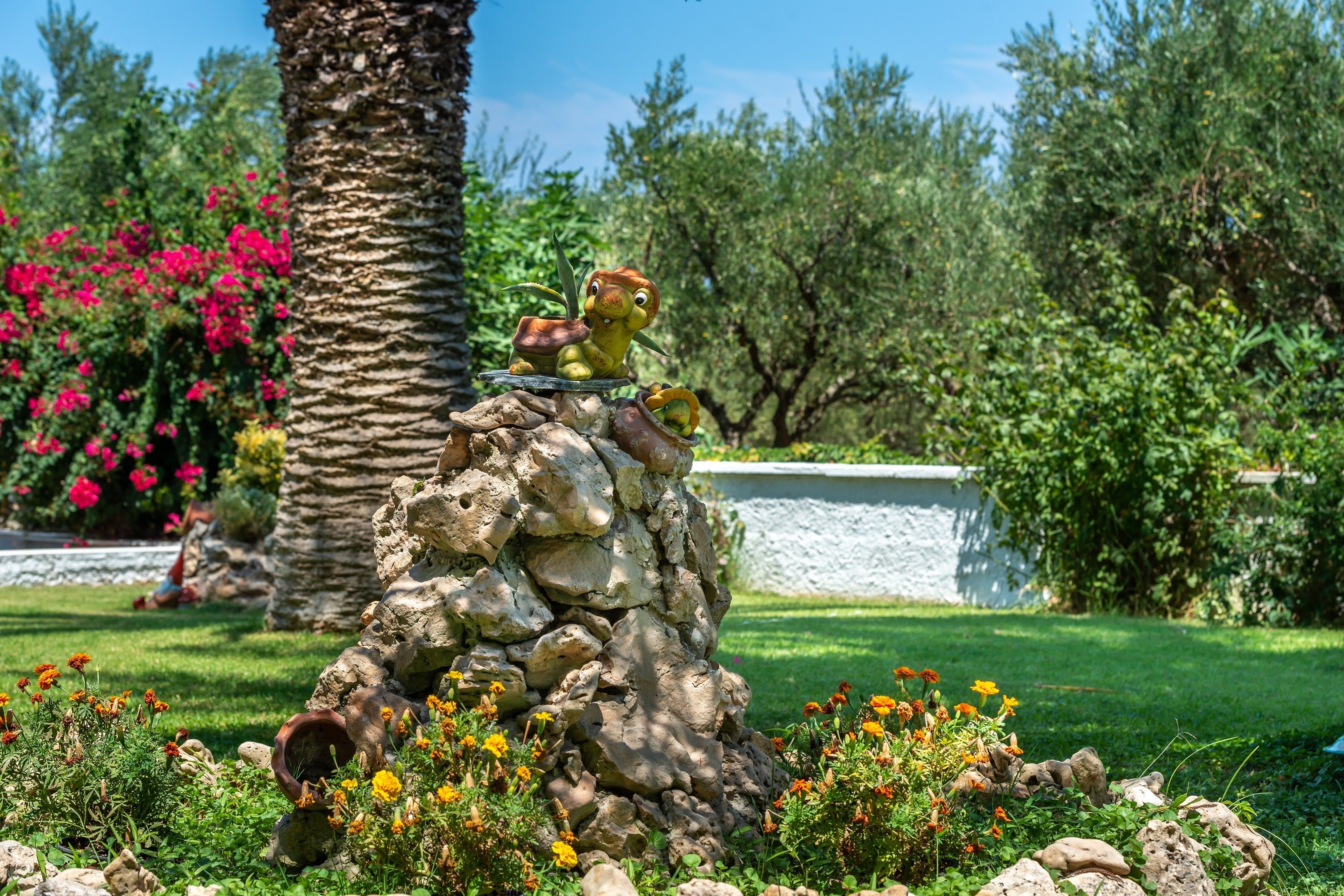 A garden with a rock formation and a statue of a character.