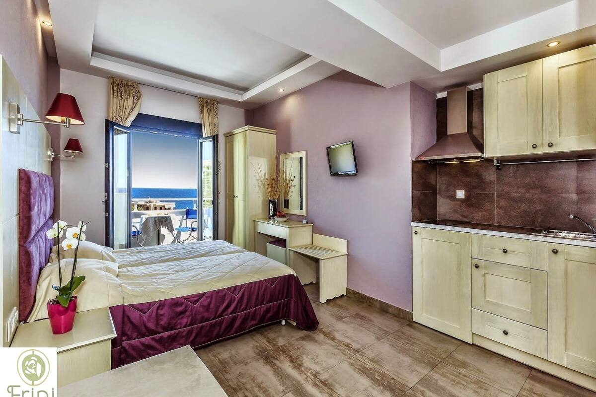 A modern bedroom with a bed, bedside table, and a view of the sea.
