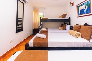 Una habitación de hotel con dos literas, un espejo, un cuadro y una ventana con cortinas.
