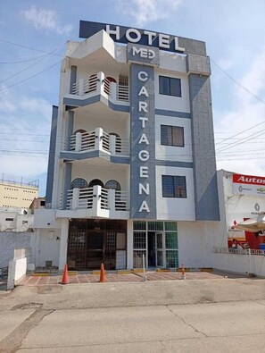 Un hotel de varios pisos con un letrero llamativo que dice 'HOTEL MED CARTAGENA'.
