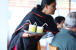 Una persona sirviendo bebidas a una mesa.