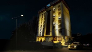 A multi-story hotel with illuminated balconies and a prominent 'Hotel' sign. - Olive Eva (Kanayannur)