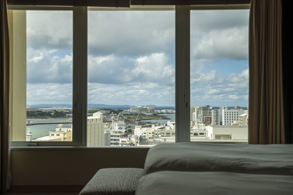 Une chambre d’hôtel dotée d’une grande fenêtre donnant sur le paysage urbain.
