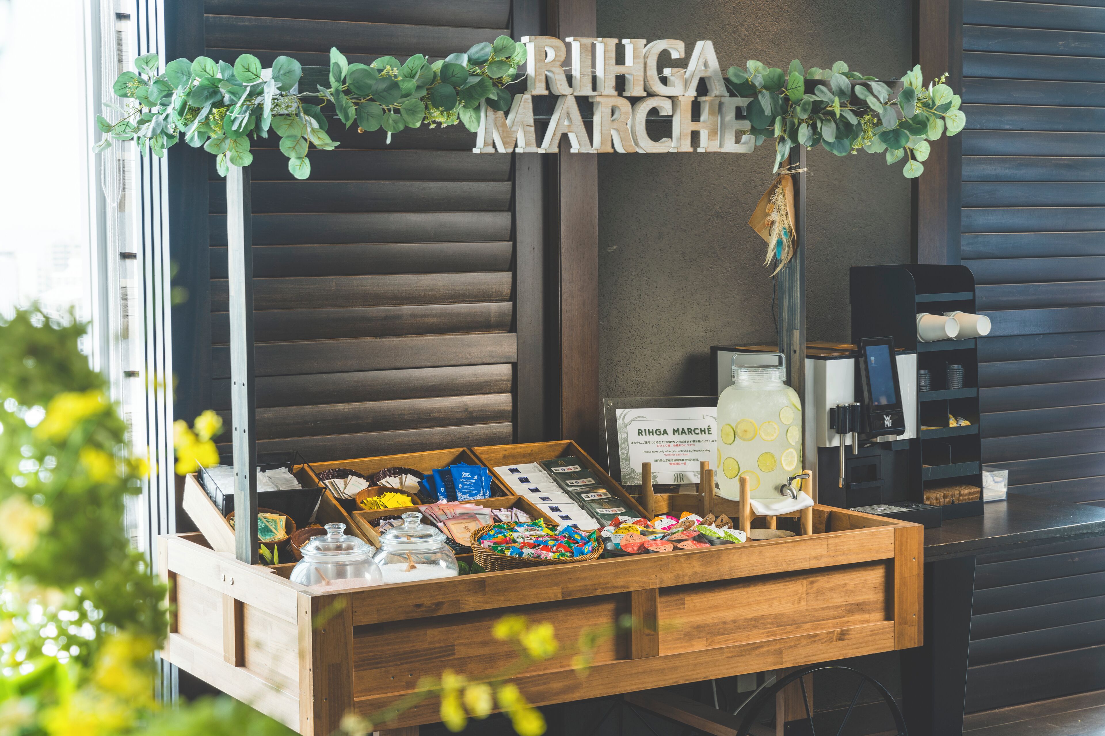 A wooden crate with a sign reading "RIHGA MARCHÉ" and various packaged goods.