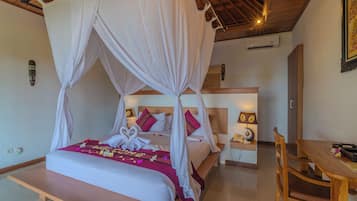 A room with a bed under a canopy, a bedside table with a lamp, and a wooden chair.