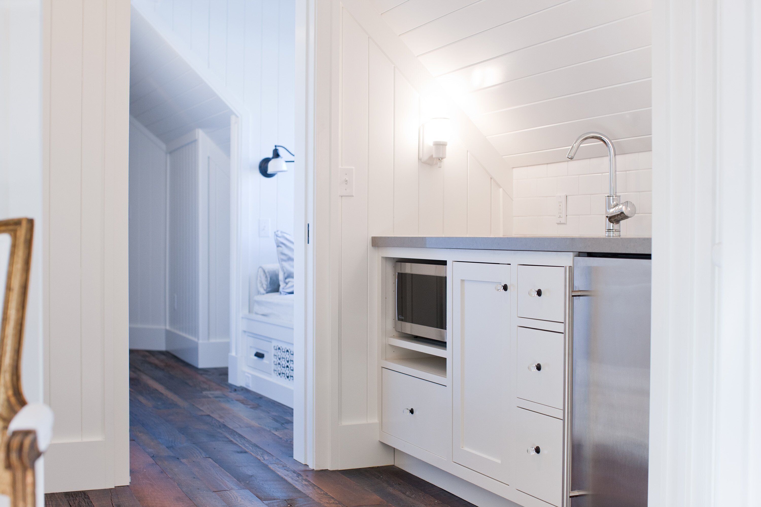 A kitchen with white cabinetry, a stainless steel refrigerator, and a built-in oven.