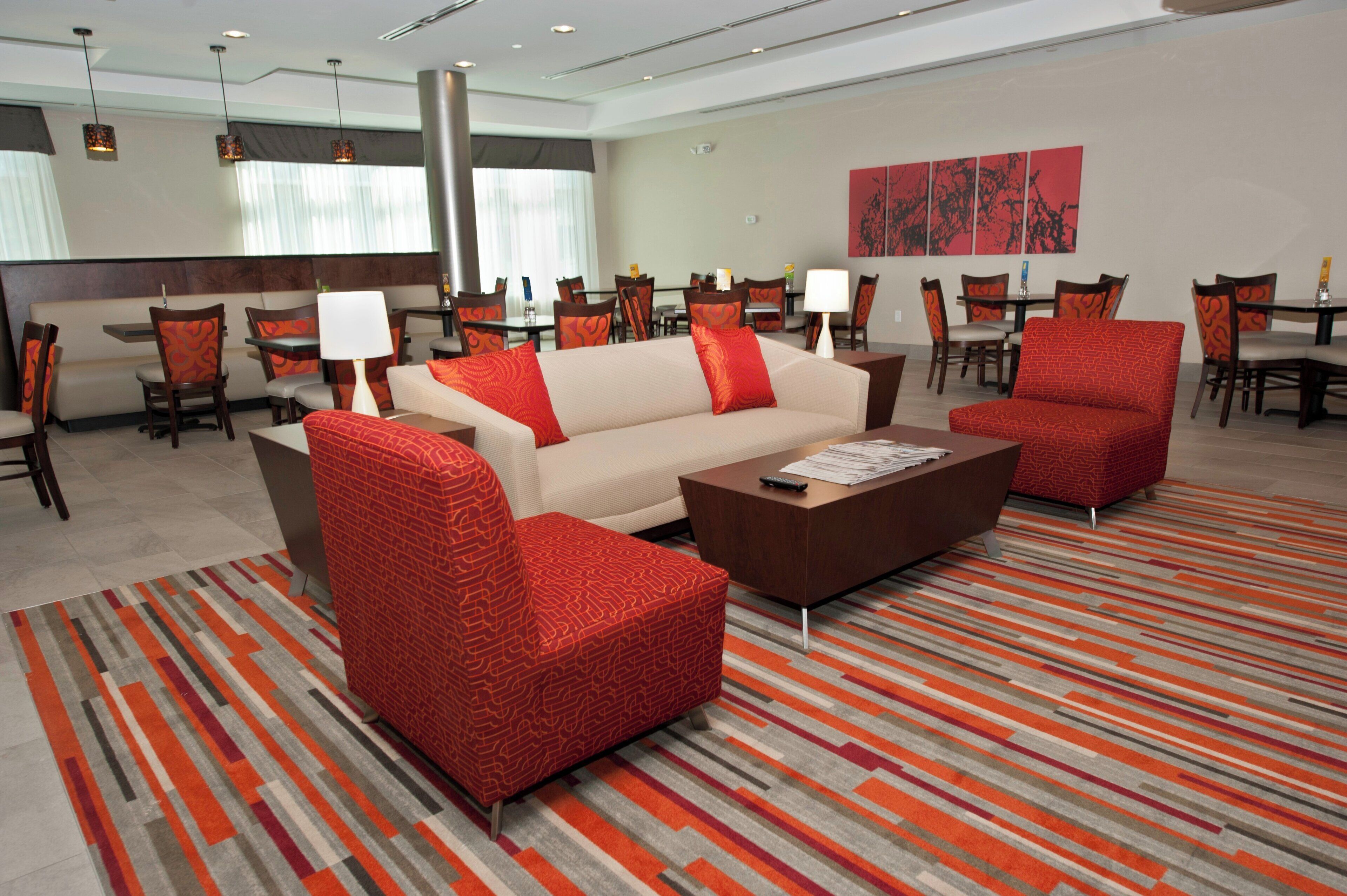 A hotel lobby with a sofa, armchairs, a coffee table, and a patterned carpet.