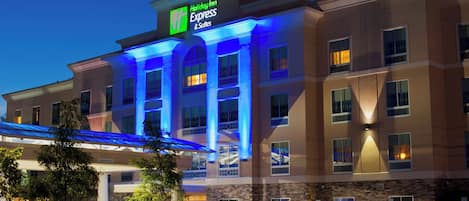 Un hôtel Holiday Inn Express & Suites doté d’une entrée bien visible, d’un espace de stationnement et d’une façade bien éclairée.