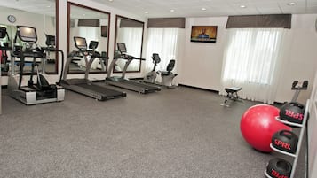 Una palestra con tapis roulant, cyclette ed elastici per esercizi.