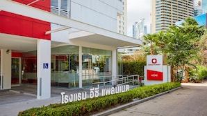 A modern building with a red and white facade, a glass entrance, and a sign for Easy Planet Asoke. - Easy Planet Bangkok Asoke (Bangkok)