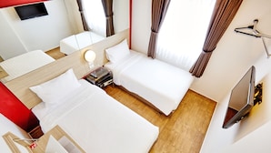 A hotel room with two beds, a TV, a desk with a laptop, and a mirror. - Easy Planet Bangkok Asoke (Bangkok)