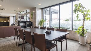A modern conference room with a large table, chairs, and a potted plant. - KOKO STAY Kumamoto Yatsushiro (Yatsushiro)