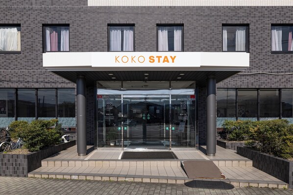 A modern building with a sign reading 'KOKO STAY' at the entrance. - KOKO STAY Kumamoto Yatsushiro (Yatsushiro)
