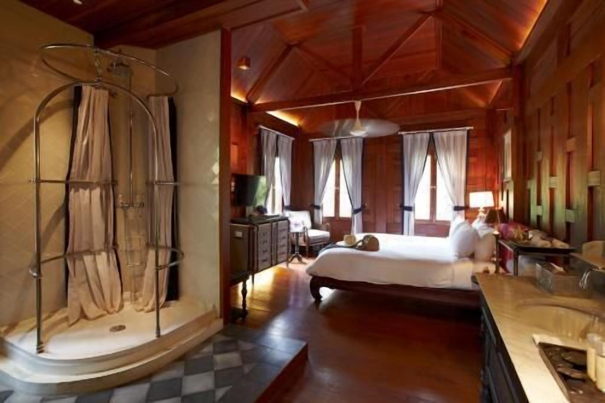 A spacious bedroom with a large bed, a vanity with a mirror, and a walk-in closet.