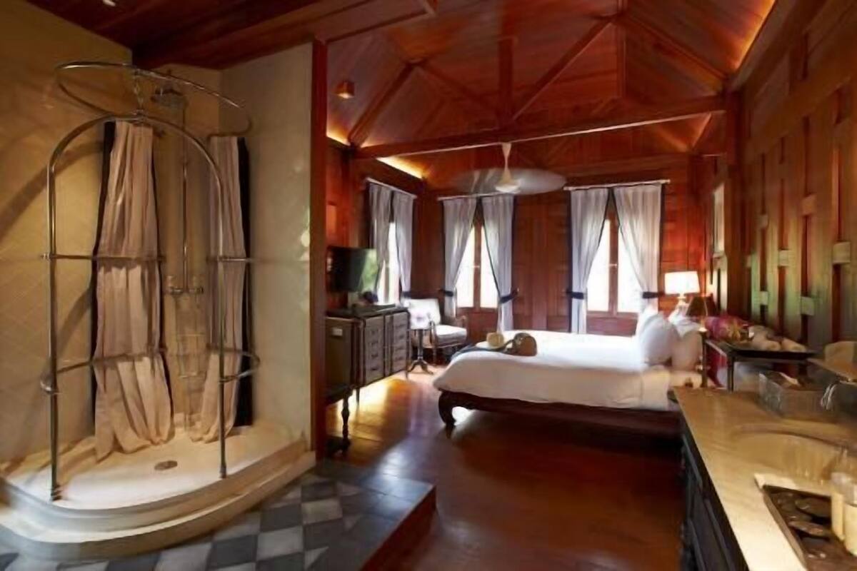 Un dormitorio amplio con una cama grande, un tocador con espejo y un vestidor.