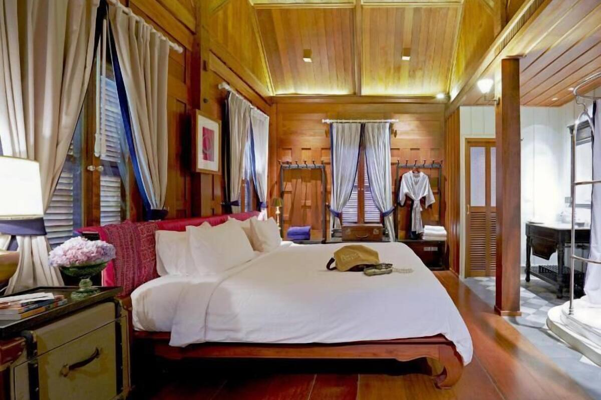 Una habitación con paneles de madera, una cama, un escritorio y una silla.