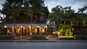 A traditional wooden building with a covered outdoor seating area and a well-lit entrance. - Burasari Heritage Luang Prabang (Luang Prabang)