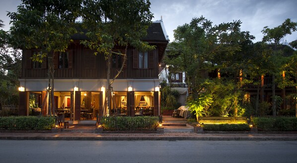 A traditional wooden building with a covered outdoor seating area and a well-lit entrance.