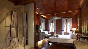 A spacious bedroom with a large bed, a wooden ceiling, and a shower area with curtains. - Burasari Heritage Luang Prabang (Luang Prabang)
