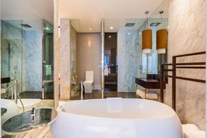 Deluxe suite | Badkamer | Een bad/douchecombinatie, een diep bad, een regendouche