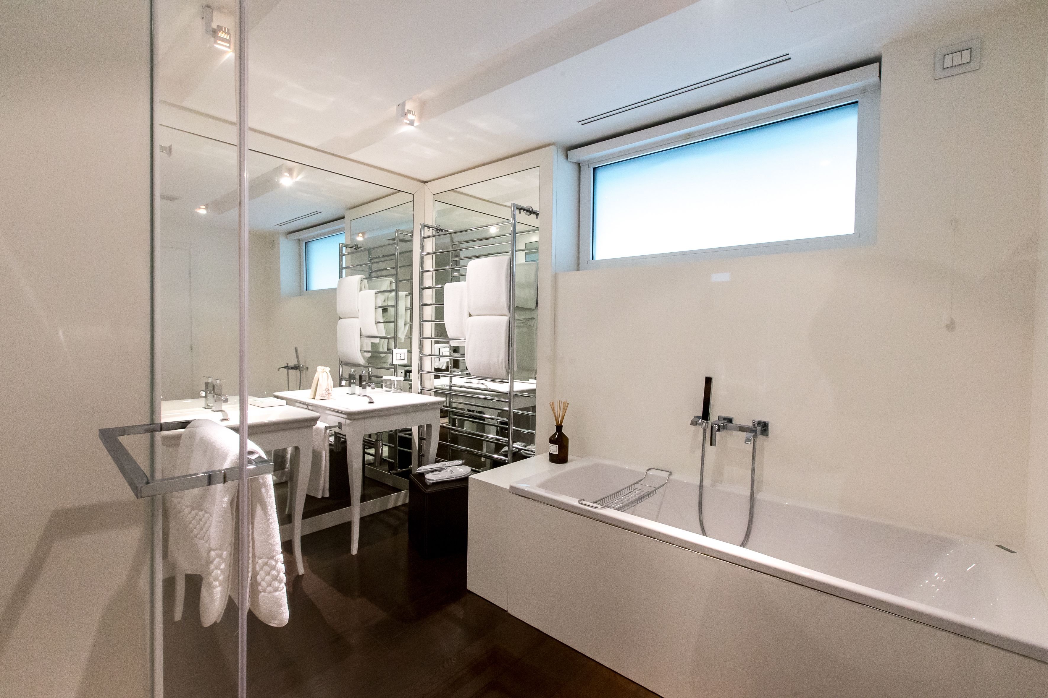 Un bagno moderno con una vasca da bagno spaziosa, cabina doccia in vetro e un mobile lavabo con specchio.