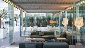 Un espace de détente moderne avec des murs en verre, des sièges confortables et des luminaires élégants.