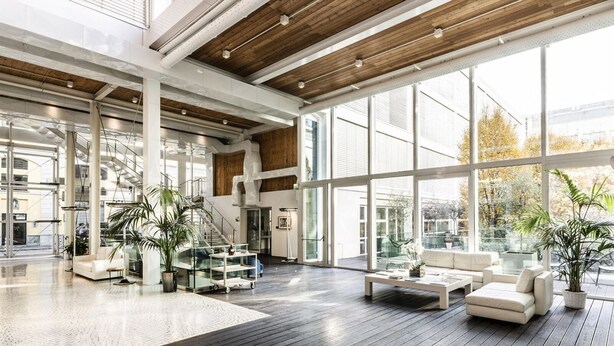 Un hall d’entrée spacieux, doté de hauts plafonds, de grandes fenêtres et d’un mobilier moderne.