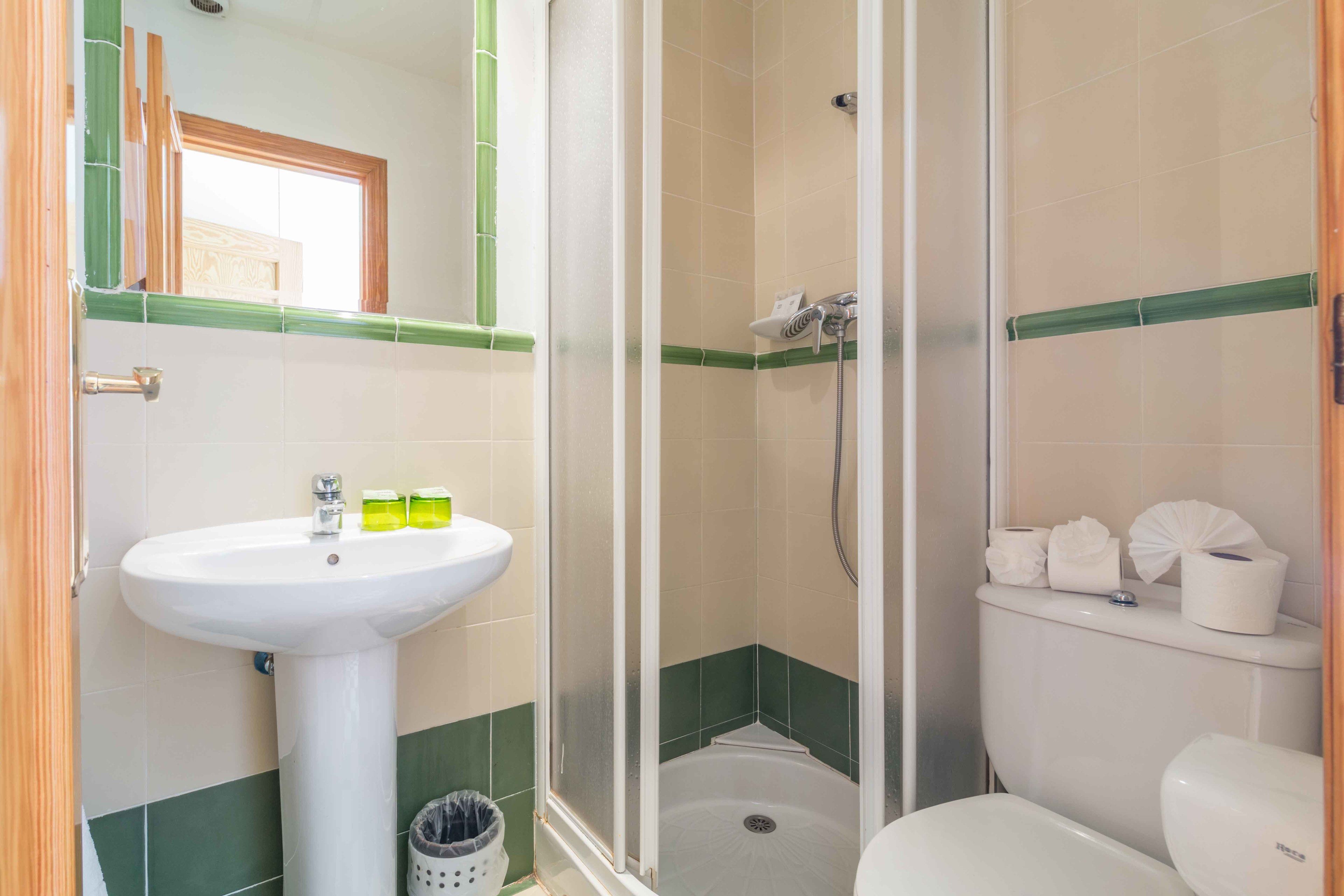 Un baño con lavamanos, inodoro y cabina de ducha.