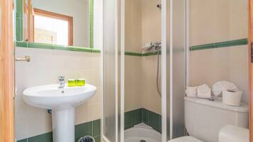 Un baño con lavamanos, inodoro y cabina de ducha.