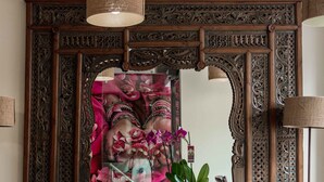 A mirror with intricate woodwork and a potted plant in front. - Terra de Mar Boutique Calpe (Calpe)
