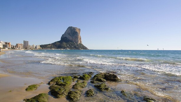 A beach with rocky formations and a prominent cliff in the background. - Terra de Mar Boutique Calpe (Calpe)