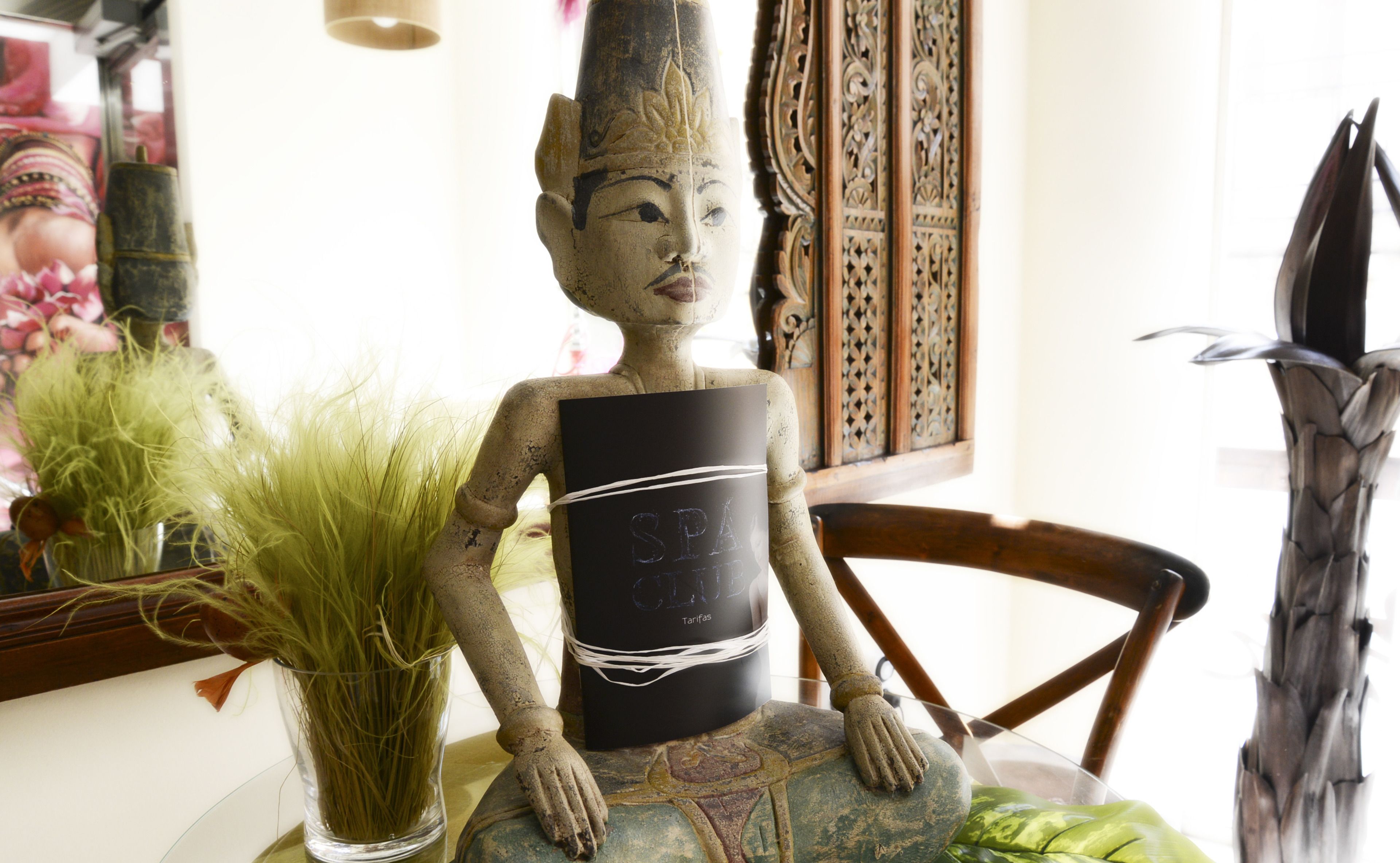 Una estatua con una etiqueta negra en el pecho, colocada sobre una silla.