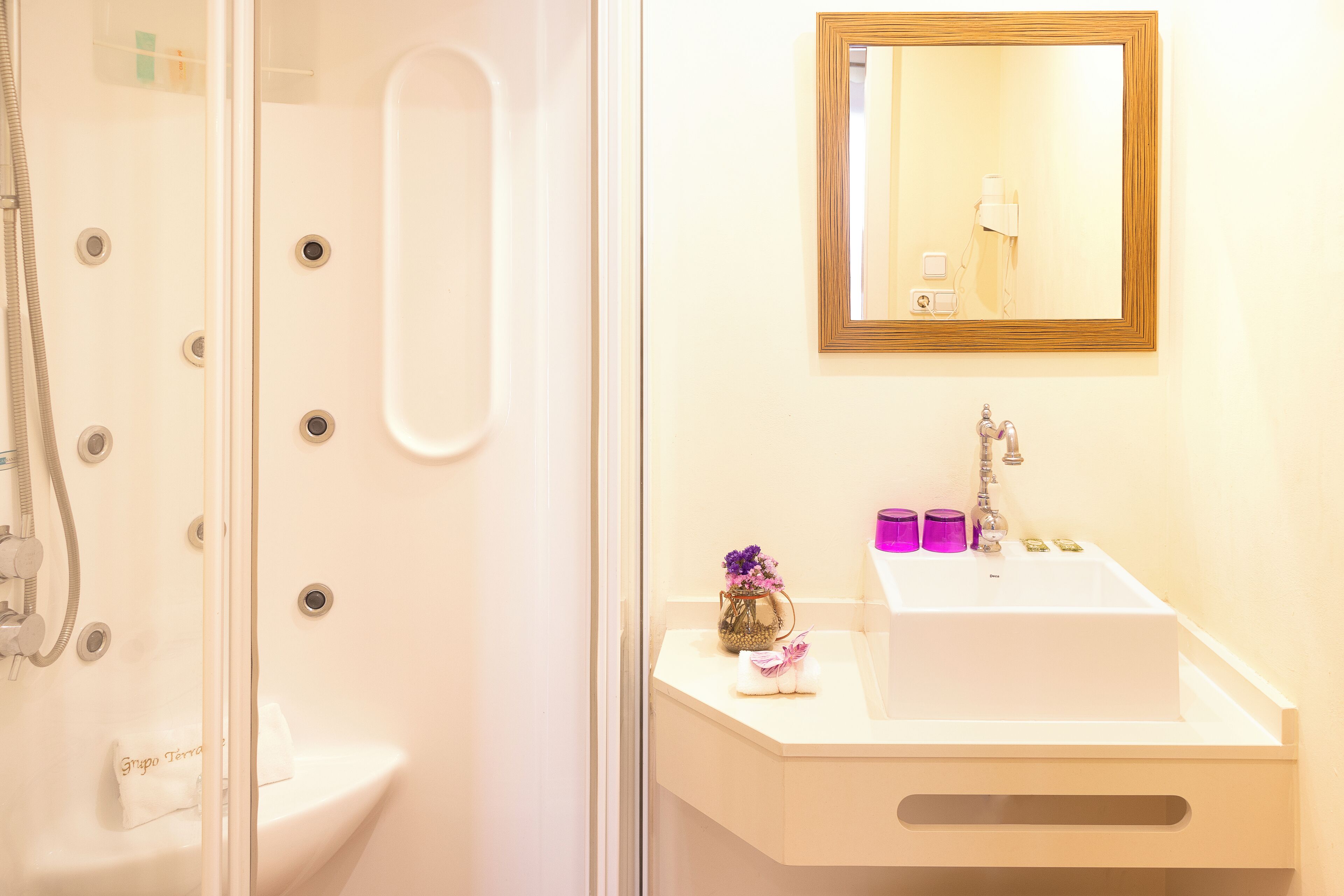 A bathroom with a shower, a sink, and a mirror.