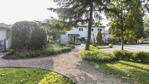 A well-maintained garden with a gravel path leading to a building with a green roof. - Hotel La Rescossa (Mira)