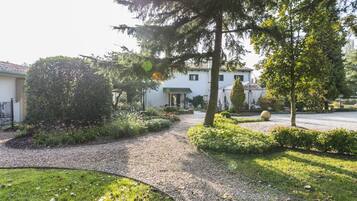 Un giardino curato con un vialetto ghiaioso che conduce a un edificio con tetto verde.