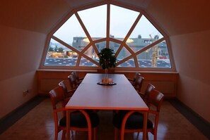 Ein Essbereich mit Tisch und Stühlen, einem Blumentopf und einem großen Fenster mit Blick auf die Stadt.