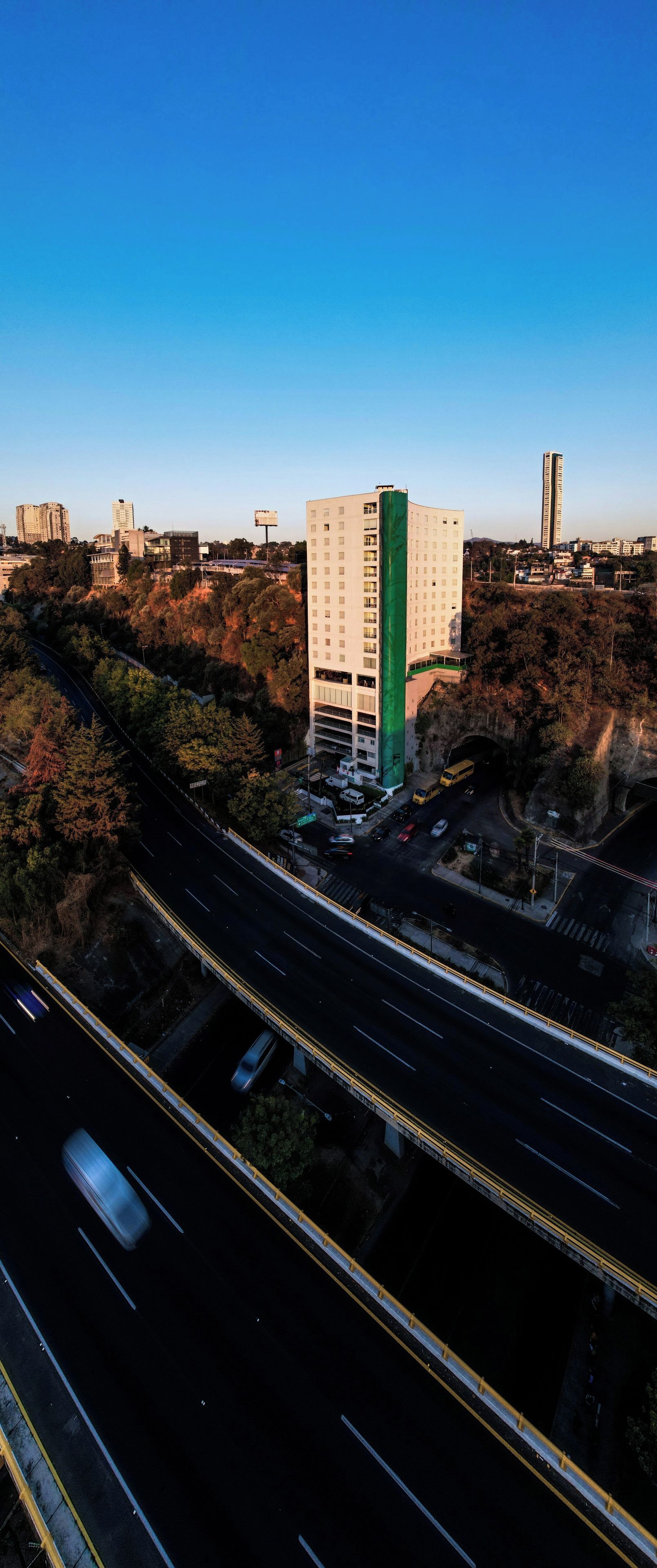 A multi-level parking structure adjacent to a highway with a clear view of the surrounding urban landscape.