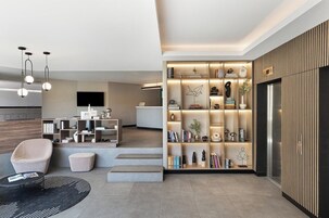 Un salon moderne avec un canapé, une table basse et une bibliothèque.