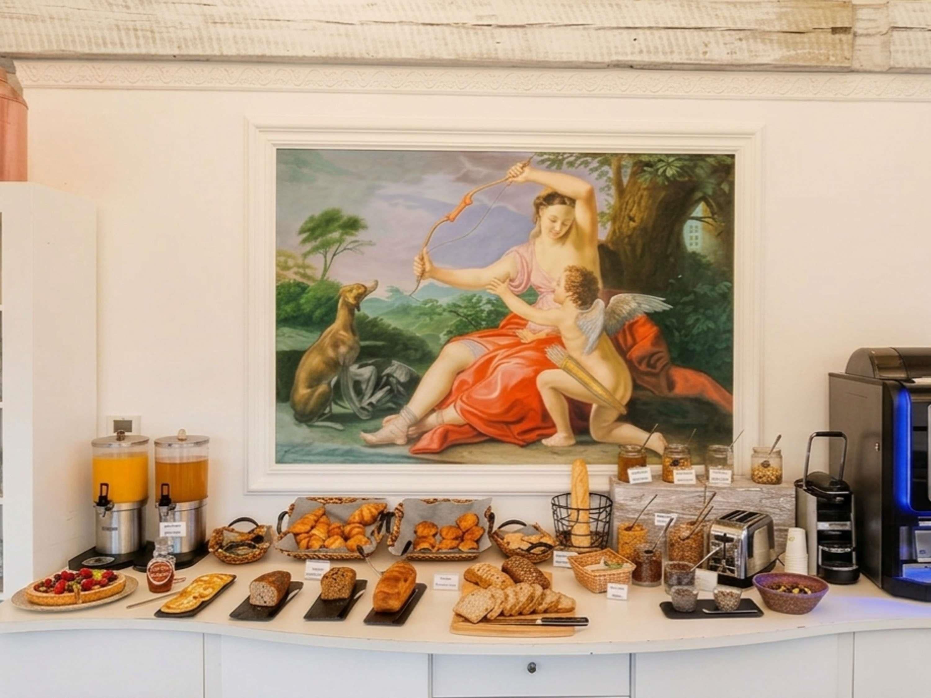 A breakfast buffet with pastries, bread, and spreads, and a classical painting above it.
