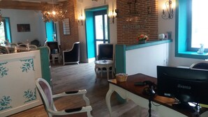 A room with a wooden floor, a desk with a computer, a chair, and a table with a basket. There is a brick wall with a window and a wall-mounted light fixture. - Hôtel Mercure Villeneuve sur Lot Moulin de Madame (Villeneuve-sur-Lot)