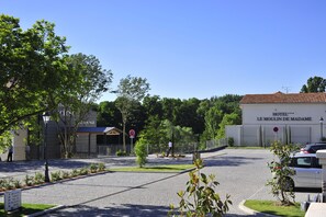 Welcome to Hotel Le Moulin de Madame, set amidst lush greenery with a charming entrance.
